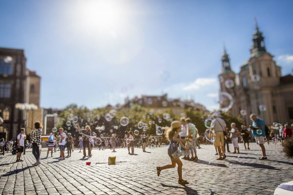 happy summer day and children playing on old town square in prague