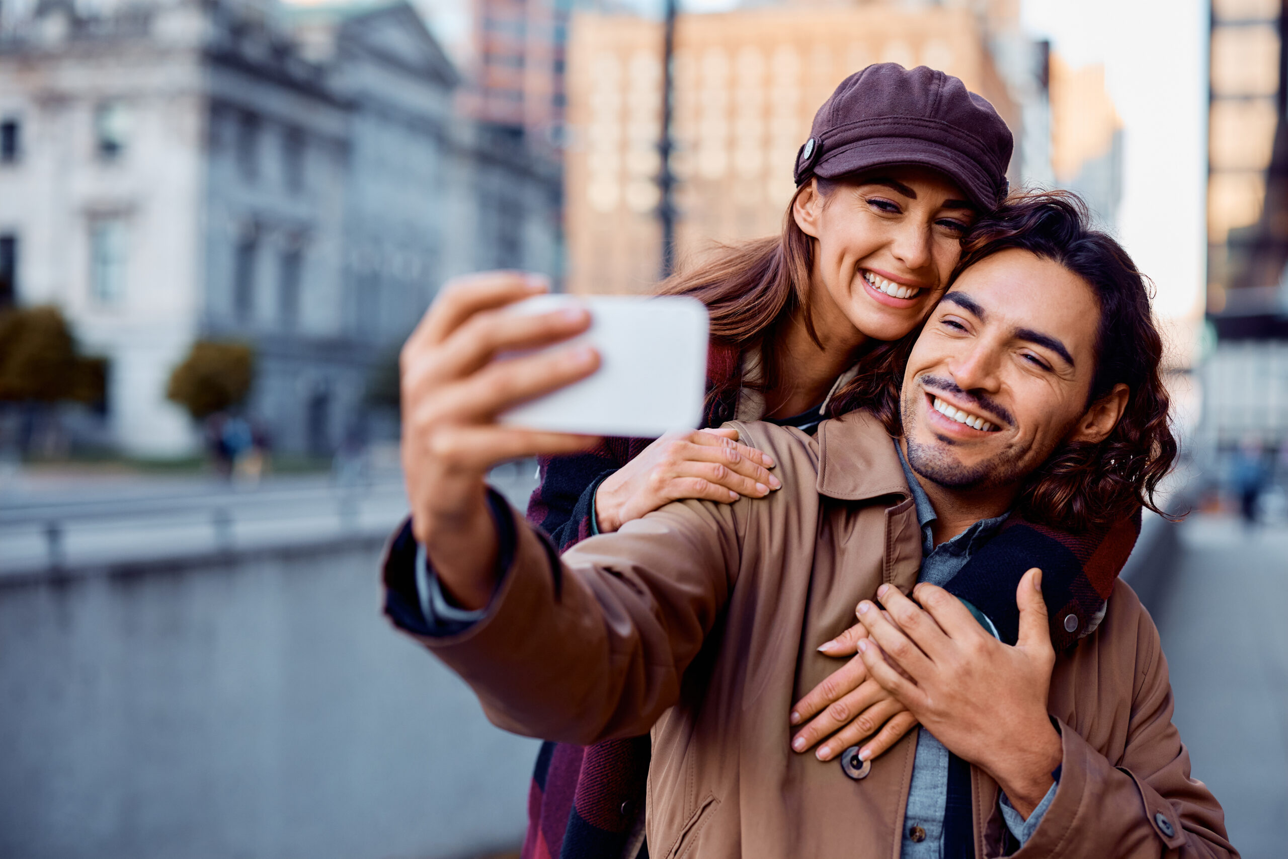 A happy couple taking a selfie in front of the famous liberty bridge during summer in Budapest in Hungary